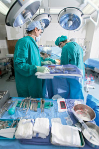 Surgeons Performing Surgery --- Image by © Robert Llewellyn/CORBIS