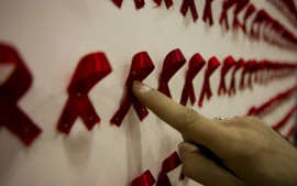 A man points at an exhibit at a conceptual art show about HIV/AIDS in Tehran, December 2, 2007.